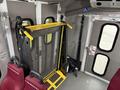 2017 Ford E450 equipped with a yellow wheelchair lift in the interior with red seats and safety straps visible