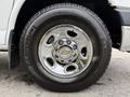 A close-up of a chrome wheel rim with a Chevrolet logo and a Michelin tire on a 2004 Chevrolet Express van