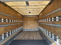 Interior of a 2012 Hino 338 box truck showing wooden walls and a wooden floor with metal tracks along the sides for securing cargo