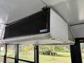 An air conditioning unit mounted on the ceiling inside a bus
