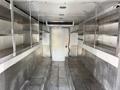 Interior of a 2017 Freightliner MT45 with metallic walls and shelves on both sides empty space for cargo and a rear door