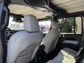 Interior view of a 2021 Jeep Gladiator showcasing the rear seats in light gray leather with an emphasis on the spacious and rugged design