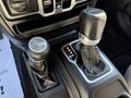 Close-up of the gear shift area in a 2021 Jeep Gladiator featuring two shift levers one for 2H 4H and 4L and the other for automatic transmission with P R N D settings