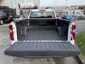 A 2024 Chevrolet Silverado 1500 pickup truck with an open bed showing a textured rubber lining and a red tailgate