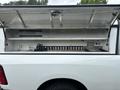 A 2016 RAM 1500 with an open truck bed cap showing shelves and storage space inside