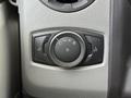 Close-up of a control dial featuring light settings in a 2022 Ford E-450 with textured gray surface and distinct symbols for headlights and interior lights