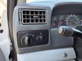 Close-up of the dashboard controls of a 2008 Ford F-750 featuring knobs and gauges for air conditioning and other functions
