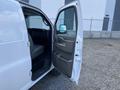 A 2023 GMC Savana van with an open front door revealing the driver’s seat and interior controls