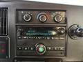 Dashboard of a 2019 Chevrolet Express showing climate controls and a radio display with various buttons and knobs