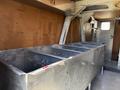 Interior of a 2009 Kenworth T270 showing a long metallic storage unit with multiple compartments and a corrugated floor