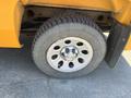 Close-up of a silver alloy wheel with the Chevrolet logo and a black tire on a 2013 Chevrolet Silverado 1500