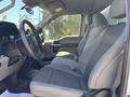 Interior view of a 2019 Ford F-150 featuring gray cloth seats and a steering wheel with a dashboard layout including gauges and controls