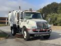 A 2012 International DuraStar 4300 street cleaning truck with a large white body and a front-mounted broom attachment