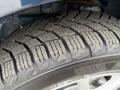 A close-up of a tire from a 2013 Dodge Journey showing a detailed tread pattern with rubber wear visible