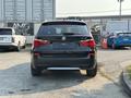 A black 2013 BMW X3 viewed from the rear showcasing its sleek design and distinctive tail lights