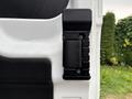 A close-up of a black door latch mechanism mounted on a white panel of a 2020 Ford Transit 250