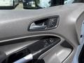 Close-up of the interior door panel of a 2021 Ford Transit Connect featuring window controls and a handle