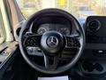 Steering wheel and dashboard of a 2020 Mercedes-Benz Sprinter featuring a Mercedes logo and control buttons