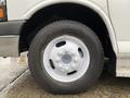 A close-up view of a white wheel and tire from a 2015 Chevrolet Express with six lug nuts visible on the rim