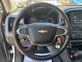 A 2017 Chevrolet Colorado steering wheel with central logo controls and dashboard gauges in the background