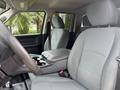 Interior of a 2016 RAM 1500 showing two front seats and a center console with storage space and cup holders