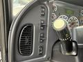 The interior dashboard of a 2016 Freightliner 108SD featuring various control buttons and a gear shift lever