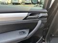 Close-up of the door panel of a 2013 BMW X3 featuring a sleek handle and control buttons with leather and metallic accents