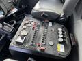 A control panel with various buttons gauges and switches located next to a driver's seat in a 2012 International DuraStar 4300 truck