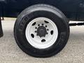 A close-up of a white truck wheel with a black tire featuring the brand name and model number clearly visible on the sidewall