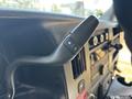 Close-up of the gear shift lever in a 2020 Chevrolet Express featuring a button with plus and minus symbols for gear selection
