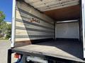 A 2022 Isuzu NQR truck with an open cargo area showing wooden flooring and metal side rails along the walls