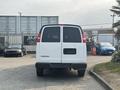 A white 2021 Chevrolet Express van viewed from the rear with a blank license plate and red taillights