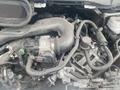 A close-up view of the engine compartment of a 2024 Ford Transit showcasing various hoses and components including the air intake and throttle body assembly