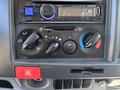 Dashboard controls of a 2016 Isuzu NPR-HD including audio system and climate control settings