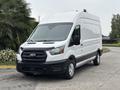 A 2020 Ford Transit 250 van with a white exterior and black accents parked on a driveway