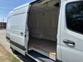 A 2019 Mercedes-Benz Sprinter van with an open side door revealing an empty cargo space and wooden flooring