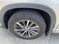 A close-up of a tire and wheel from a 2018 Toyota Highlander showcasing the alloy rim and tread pattern of the tire