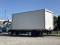 A white 2018 Hino 195 box truck with no visible markings parked on a driveway facing left