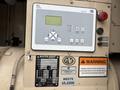 A digital control panel for a 2005 Katolight SED60FPJ4 featuring buttons and a display screen along with warning and specification labels