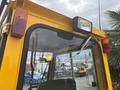 A yellow 2004 Bombardier SW48 vehicle with a prominent rear-view mirror and various lights mounted on the back and sides