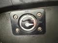 A round control dial with an on-off switch and indicator markings mounted on a black panel