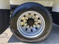 Close-up of a shiny chrome wheel of a 2008 International DuraStar featuring multiple lug nut holes and a rugged tire tread design