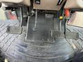The image shows the foot pedals and gear levers of a 2010 Kubota M6040 tractor with textured flooring in the foreground