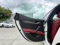 A 2016 Maserati Ghibli with a partially open door featuring black and red leather upholstery and a modern interior design