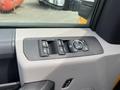 Close-up of the driver's side window control panel of a 2017 Ford F-250 SD featuring buttons for windows and a dial for mirror adjustments