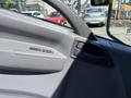 Interior view of a 2022 Isuzu NQR door panel showing the window control buttons and door handle