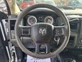 The steering wheel of a 2013 RAM 5500 featuring buttons for controls and the RAM logo in the center