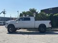 A white 2018 RAM 3500 truck with a large cargo bed and black rims is parked on a concrete surface