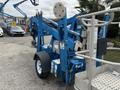 A blue 2016 Genie TZ-34/20 articulating boom lift with a basket mounted on a wheeled chassis designed for elevating workers and equipment to high places
