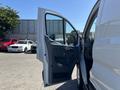 A 2016 Ford Transit with the driver's side door open showing the interior and seat area
